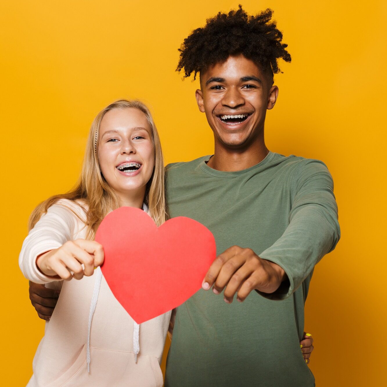 two teenagers holding a heart